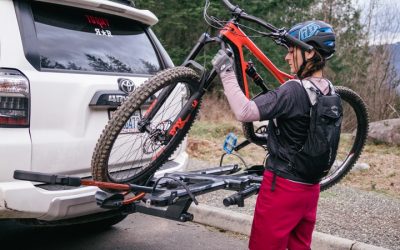 A girl hold the cycle in front car